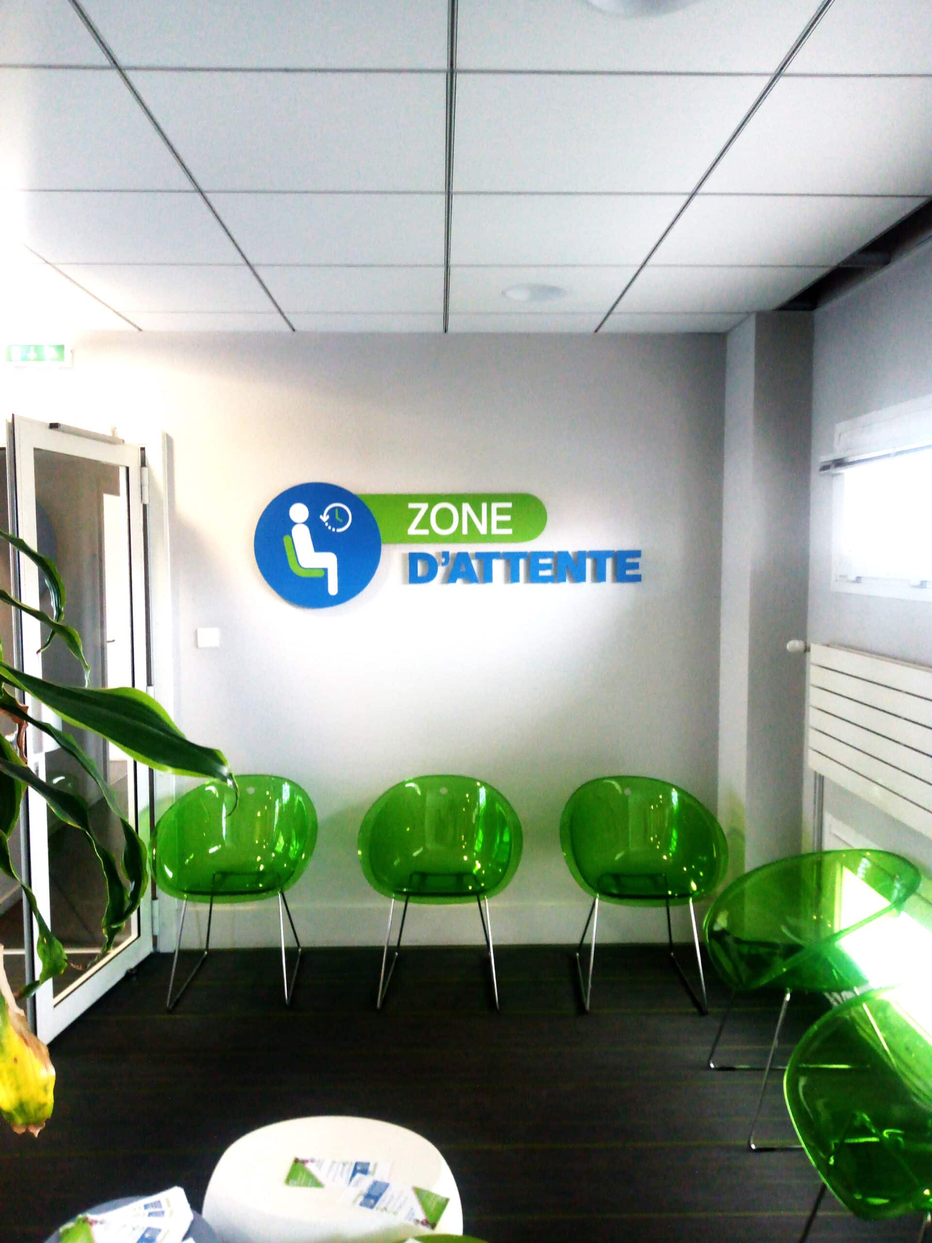 Signalétique murale bleue et verte Zone d’attente au-dessus des sièges chez Idéha